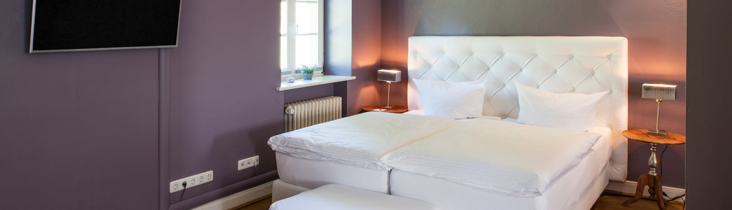 Ein frisch mit weißer Bettwäsche bezogenes Bett