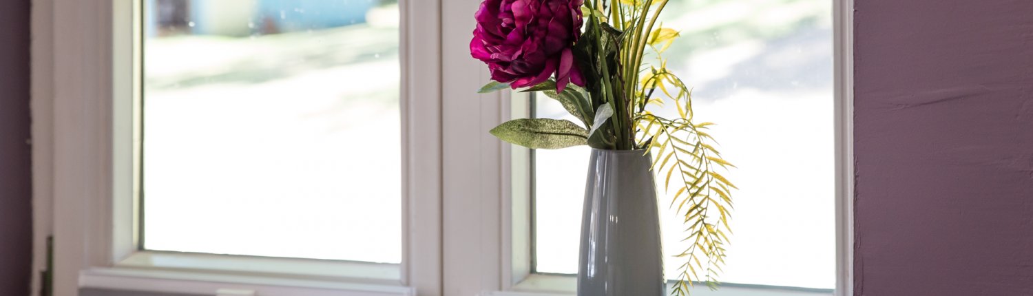 Vase mit Peonieen auf dem Fensterbrett